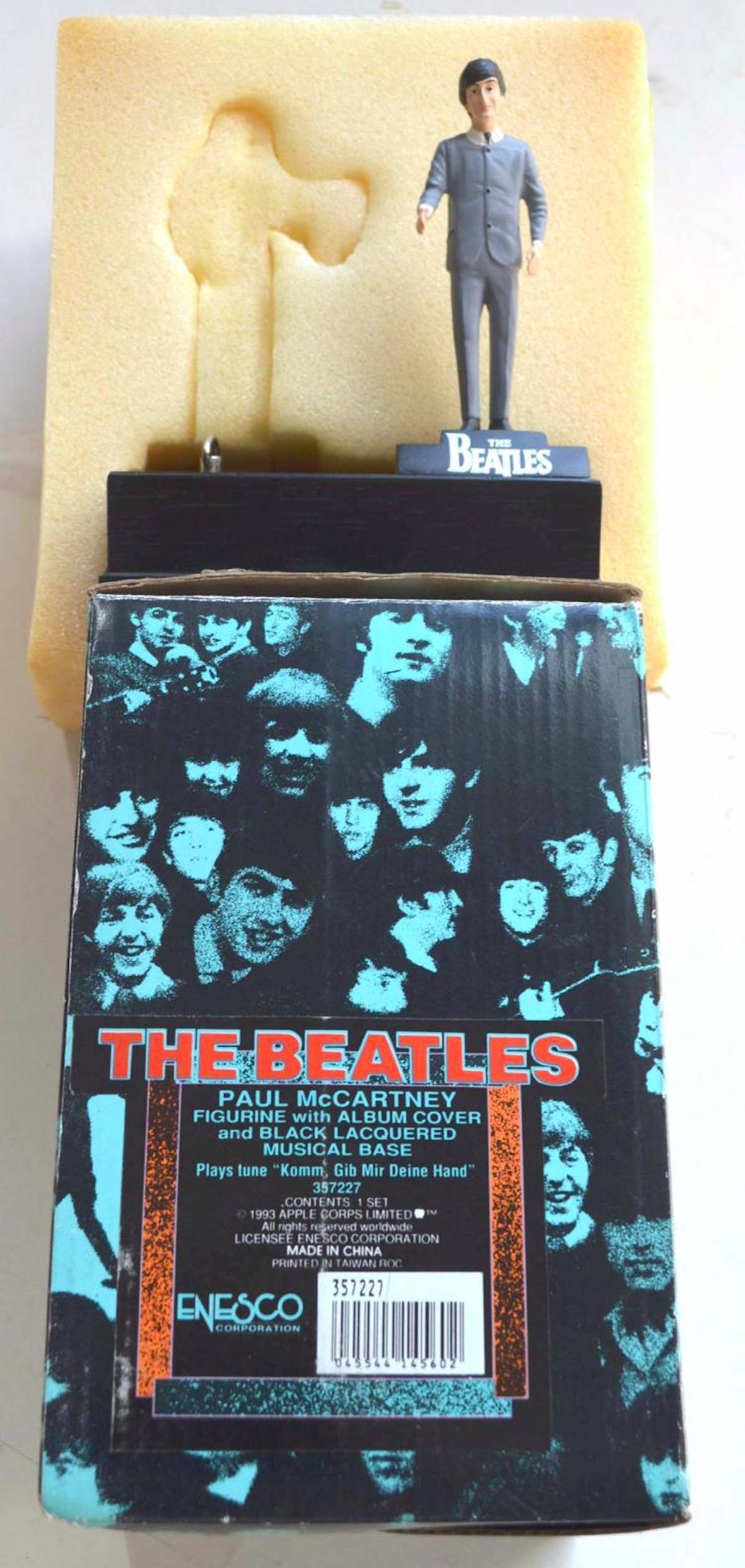 Enesco "The Beatles - Paul McCartney Figurine ": Description: The Beatles - Paul McCartney Figurine with Album Cover and Black Lacquered Musical Base. It plays tune "Komm Gib Mir Deine Hand". Figure measures at 4", with Box measures at 5" in total. 
