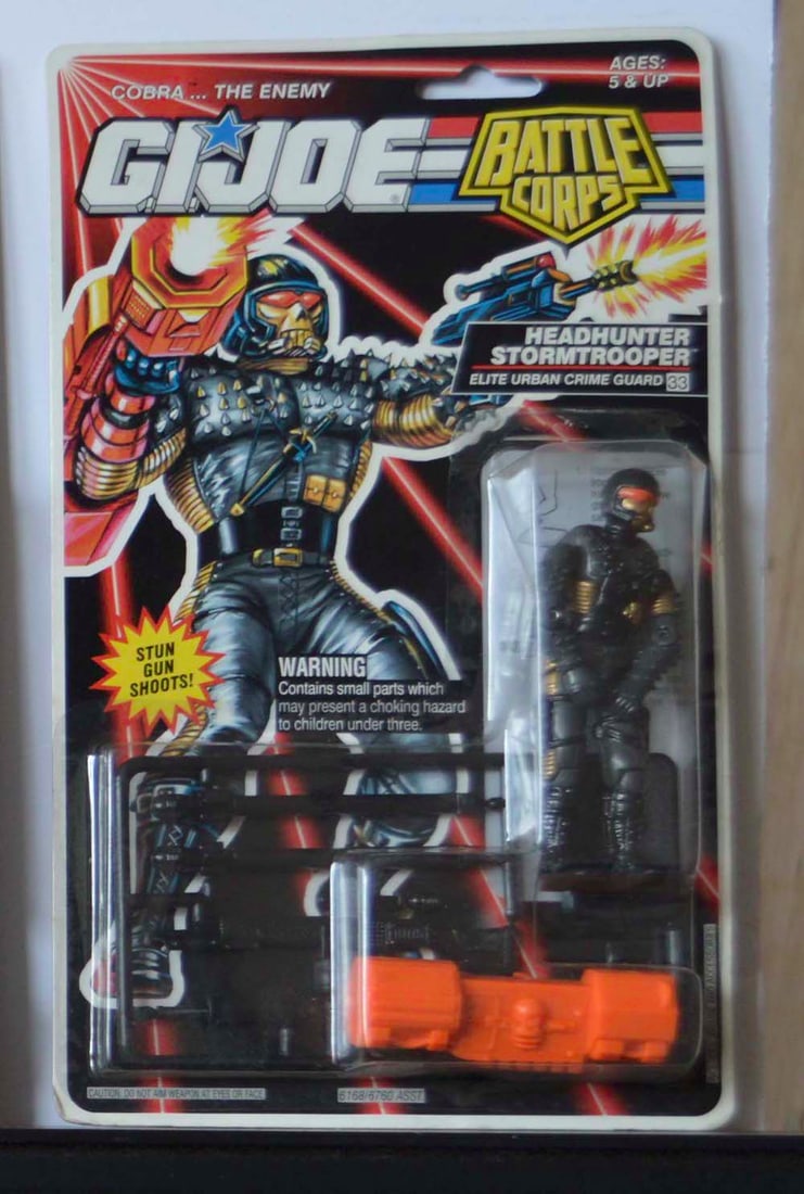 G.I. JOE "HEADHUNTER STORMTROOPER" BATTLE CORPS FIGURE ON CARD: G.I. JOE "HEADHUNTER STORMTROOPER" ELITE URBAN CRIME GUARD. BATTLE CORPS FIGURE ON CARD. 1994. Plastic pulled up from card on Top (mainly L side)