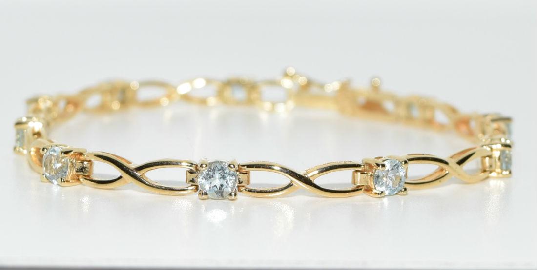 Gold Over Sterling Silver Blue Topaz Tennis Bracelet: Ten 0.25ct round cut blue topaz set in gold over sterling silver tennis bracelet | Measurement: 7" length 4.2mm width | Weight: 8 grams | Stamp: 925