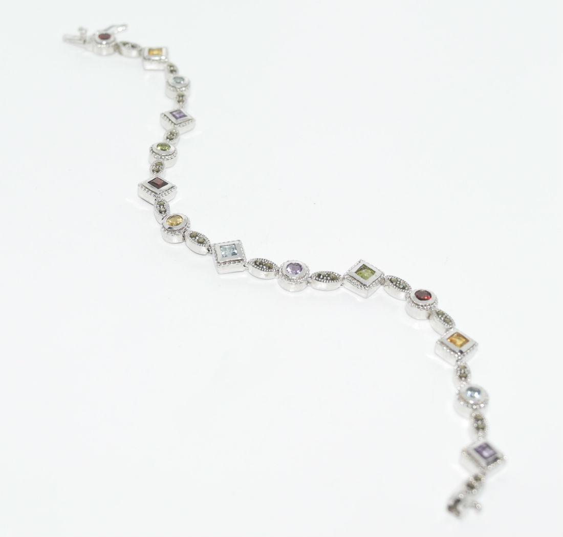 Thailand NF Sterling & Gemstone Bracelet: This bracelet is 725\" long and 7.5mm at its widest. Has Topaz, Amethyst, Citrine, Garnet, Peridot, and Marcasite stones throughout. Stamped Thailand, NF, & 925