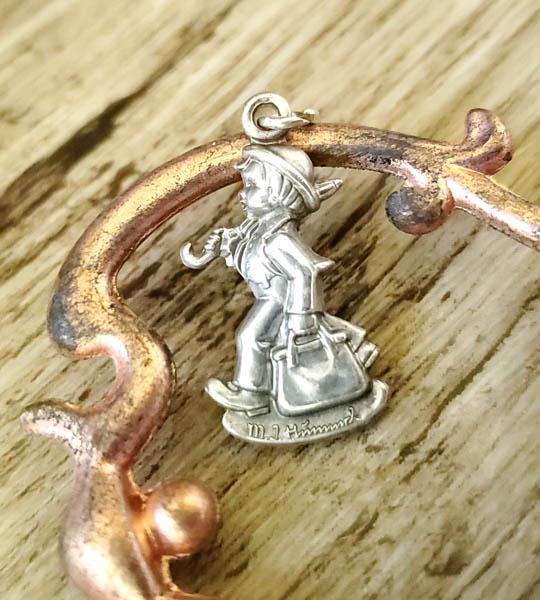 Sterling Silver MI Hummel Charm: Item Details:Sterling Silver MI Hummel Charm Type: Sterling Silver MI Hummel Charm Length: 24.5mm Width: 12.5 mm Other: N/A Weight in Grams: 2.78 Hallmarks and Stamps: Sterling, MI Hummel Club, Goebel