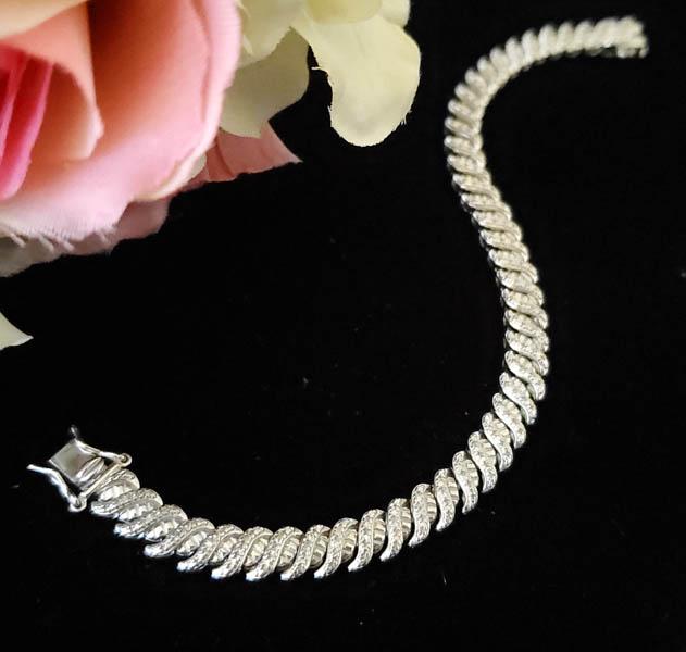 Sterling Silver Bracelet: Item Details:Sterling Silver Bracelet Type: Tennis Bracelet Length: 7 Inches Width: 6.6 mm Other: Slide Box Closure Stone Type: Diamond Accents Stone Cut: Round Stone Color: Clear Shape/Style: Classic
