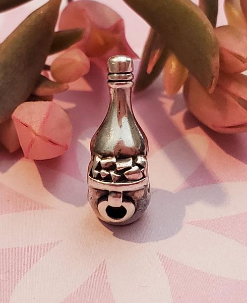 Sterling Silver Charm: Item Details:Sterling Silver Charm Type: Slide or European Charm Length: 15.5 Inches Width: 6.3 mm Other: Stone Type: None Stone Cut: None Stone Color: None Shape/Style: Champaign on Ice Carats: None 