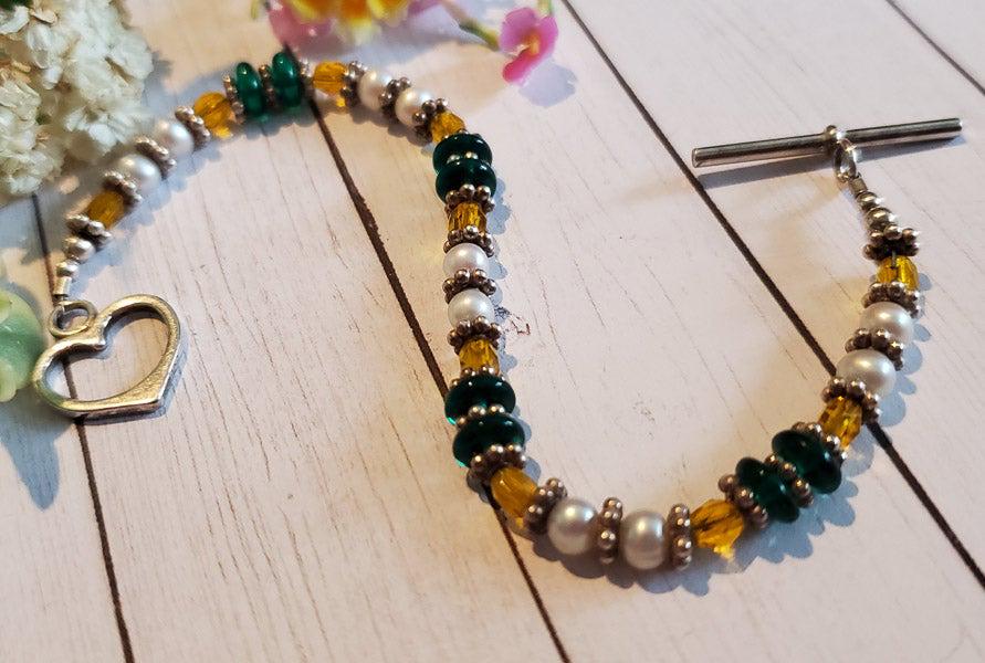 Sterling Silver Bracelet: Item Details: Bracelet Length: 6 Inches Width: 6 mm Shape/Style: Toggle Heart Stone Type: Pearls, Crystals Weight in Grams: 10 Hallmarks and Stamps: 925 Please note: All items are taken at stamped val