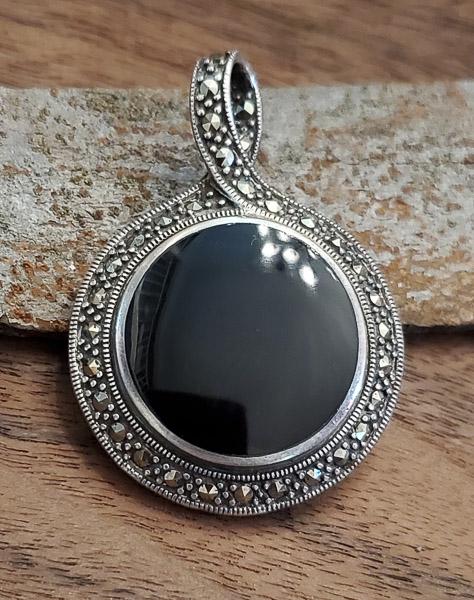 Well Crafted Sterling Marcasite and Onyx Pendant: Length: 33mm round and double-sided Weight in Grams: 21.36 Hallmarks and Stamps: 925 Please note: All items are taken at stamped value and are not tested unless stated. As with many vintage items, pie