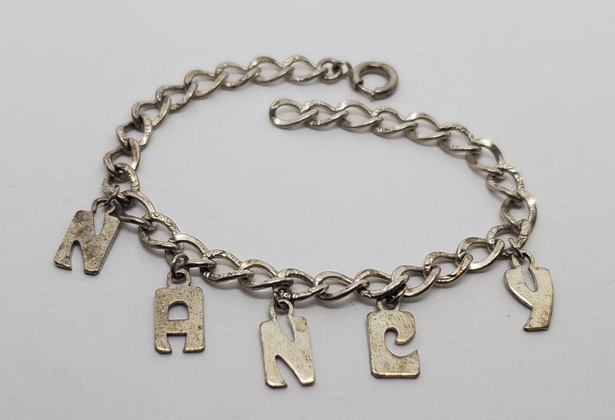 Sterling Silver Nancy Charm Bracelet: Please see pics for details as this is the exact item you will receive.Ã‚ Length: 7 inchesÃ‚ Weight in Grams: 8.62 Hallmarks and Stamps: Sterling Due to the limited amounts of cleaning and polis