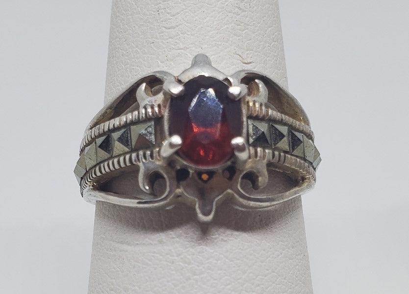 Garnet and Marcasite Sterling Silver Ring sz 7: Please see pics for details as this is the exact item you will receive.Ã‚ Size: 7 Item Details: 13mm at widest Weight in Grams: 4.35 Hallmarks & Stamps Include: 925 and testedÃ‚ Due to the l