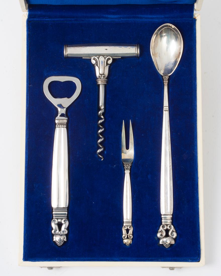 Four piece Georg Jensen Solv Hof Leverandor sterling: Description: Georg Jensen Solv Hof Leverandor sterling silver and stainless cocktail serving set. Boxed in lined blue velvet. Includes four pieces: a stirring spoon, olive fork, wine opener, and bott