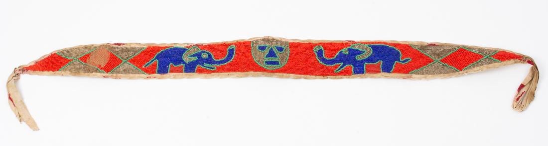 Craft Art African Diviner Sash made in Nigeria 33": Description: Diviner belt / Yoruba sash with decorative woven bead pattern including elephants and a central mask. Dimensions: 33" long x 3" wide Estimated