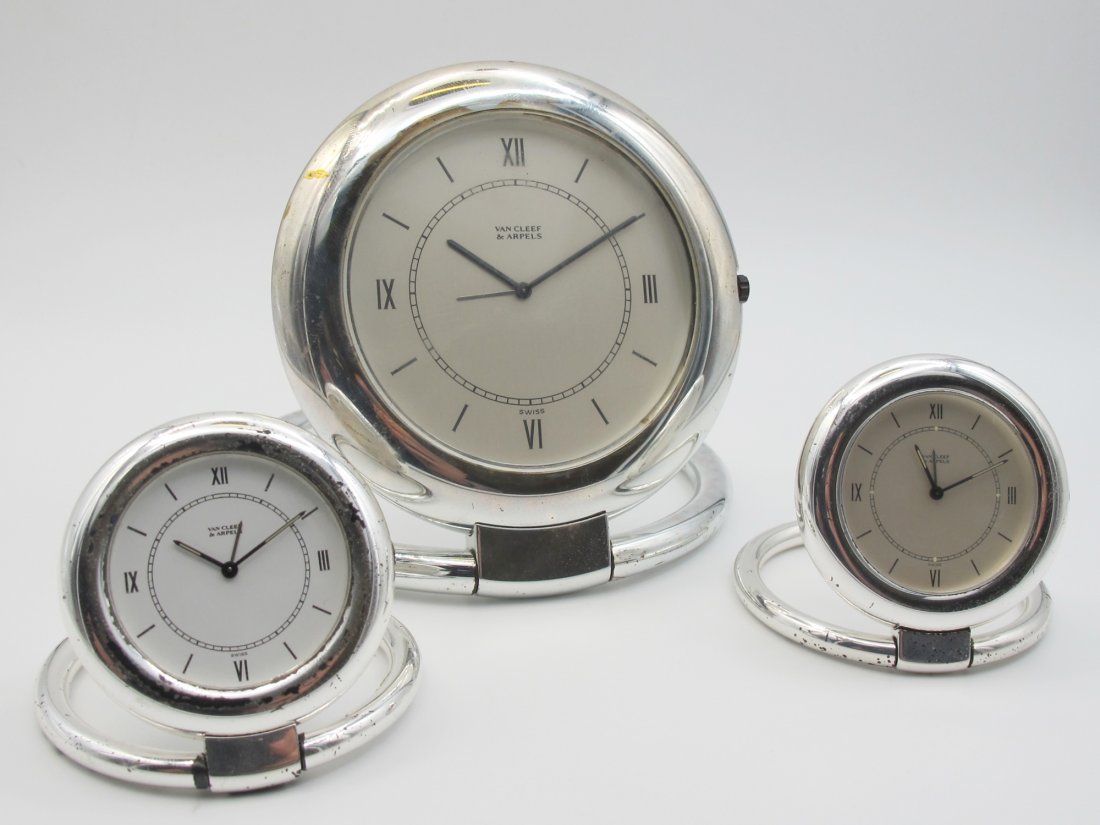 Van Cleef & Arpels: tre orologi d'appoggio in metallo bianco quadranti bianchi con indici e numeri romani in smalto nero, movimento al quarzo