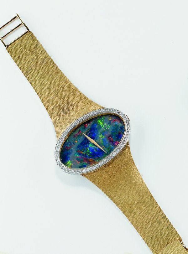 Orologio firmato Chopardcassa a bracciale in oro g: Orologio firmato Chopardcassa a bracciale in oro giallo, lavorazione acorteccia, quadrante di forma ovale in opal.Movimento a carica manuale Chopard,A lady's gold wristwatch with opal dial