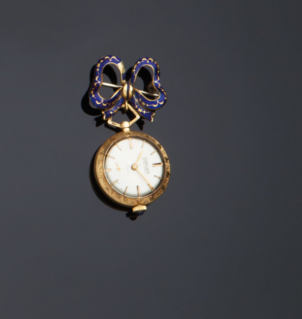 Spilla a fiocco con orologio pendente: amovibile firmato Harlem in oro giallo 18 kt con smalti blu, movimento a carica manuale. Manifattura degli anni Cinquanta. Lunghezza cm. 5,00. Gr. 19,00GOLD BROOCH WITH HANGING WATCH BY HARLEM WITH BL