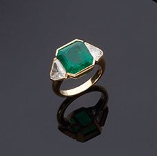 Anello in oro giallo 18 kt, Damiani: con smeraldo centrale colombiano naturale taglio ottagonale a gradini, cts. 6,00 (mm. 11.60x10.60x7.20) e ai lati due diamanti taglio a scudo, cts. 1.60, colore G/H, purezza VS. Con certificato gemmol