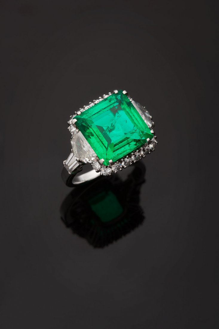 Anello in platino, Bulgari: realizzato nei primi anni Sessanta, con al centro uno smeraldotaglio quadrato a gradini, cts. 4.10 (mm. 10.66x10.60x5.22)contornato da 12 diamanti taglio brillante, scudo a gradini etapered, colore F-