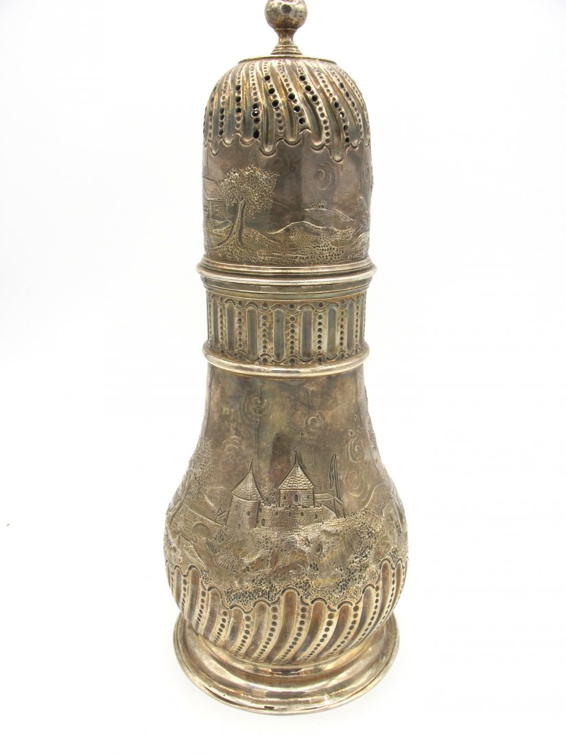 Grande spargizucchero in argento, Londra, Giorgio II: inciso e sbalzato Notes: a figure rupestri. Cm. 21. Gr. 392A silver sugar spreader, London George II with figures. 21 cm. 392gr.