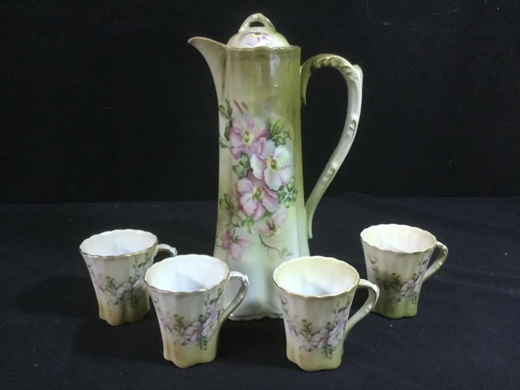 Nippon Chocolate Tea Set: Vintage hand painted chocolate set with pitcher & lid. Comes with 4 cups (1 is damaged) see pictures. The Pot is 11" tall and the cups are 3" tall. This Nippon set has a Green Wreath Hourglass Mark.