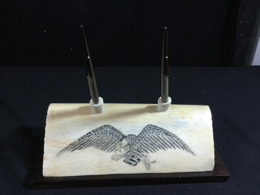 Scrimshaw Whale Bone: Scrimshawed on front a Eagle with flag that is signed. Neat pieces that measures 10"l and with base is 11 1/4"l. In great condition and comes with 2 vintage fountain pens. Value 150.00-300.00