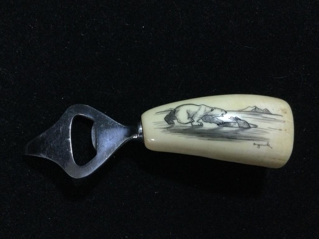 Scrimshaw Whale Tooth Bottle Opener: Signed scrimshaw of polar bear & fish bottle/can opener. In great condition. Tooth measures 3"l x 1 1/2"w.