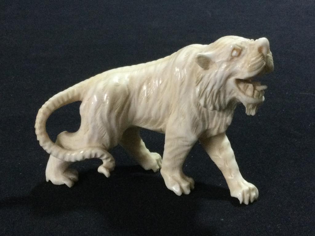 Carved Ivory Tiger: Neat piece intricately carved that measures 4"l x 2 3/4"h x 1 1/4"w. No chips or cracks. In good condition, see pictures.