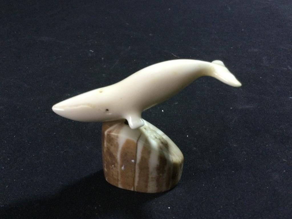 Carved Ivory on Fossilized Base: Neat carving of a Humpback whale on a fossilized base. Measures 2.5"h. The whale measures 3"l . In great condition.