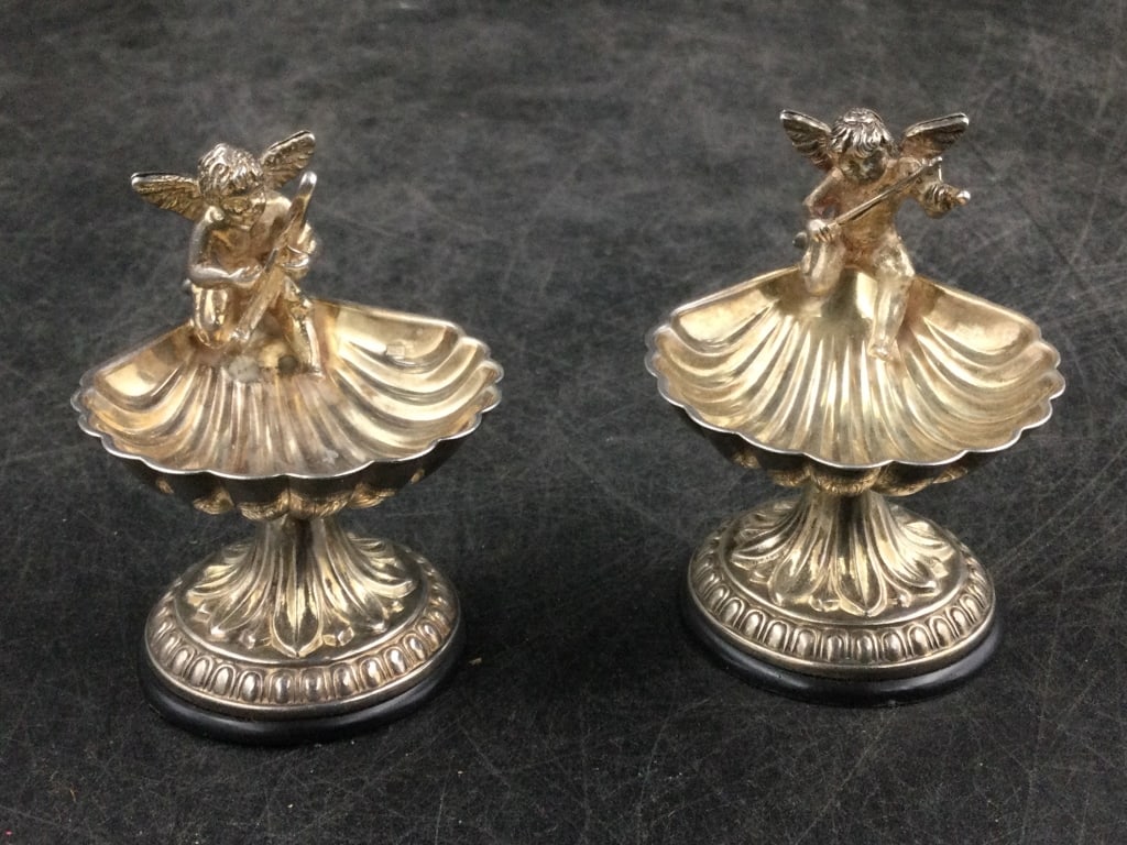 Early Sterling Salt Cellars: Pair of vintage salt cellars. Cupid seating playing instrument. Measures 2 1/4"h and condition is good, see pictures. Total weight of both is 63 4g. No refunds given.