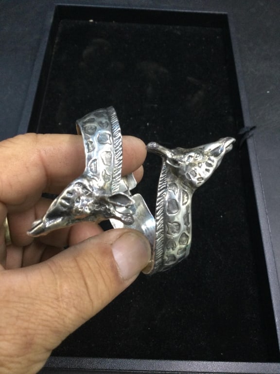 Sterling Giraffe Bracelet: Spring loaded sterling bracelet made from sterling into 2 giraffe's 56.9g. Artist signed piece. Condition is good, see pictures. No refunds given.