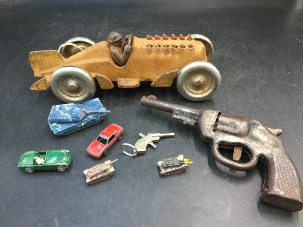 Vintage Toys: There is 3 mini tanks, cap gun, tank, mini pin gun, 2 mini cars. and toy racer. The toy racer is cast iron and marked Hubble on the bottom. It measures 10 1/2"l. Condition is good with age and use, se