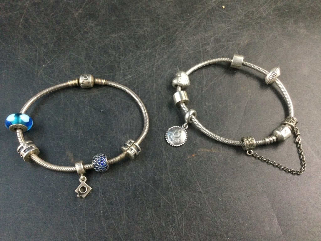 Sterling Pandora Bracelets: Two nice pandora bracelets with charms. Weighs 59.0g and they are in good condition. See pictures. No refunds given.
