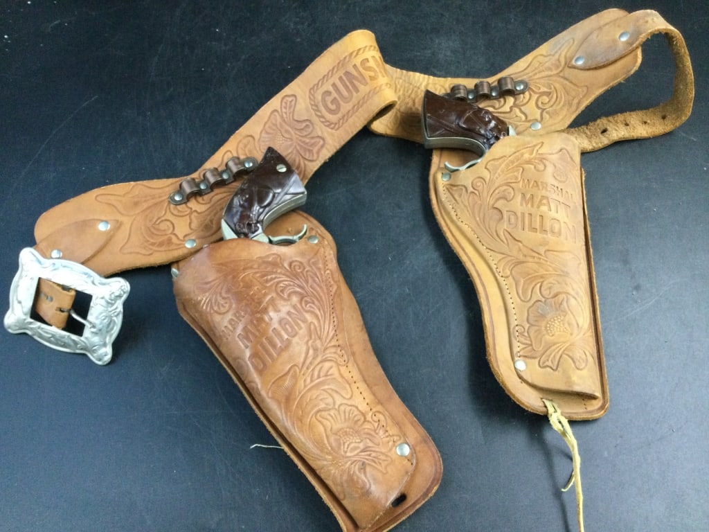 Vintage Gunsmoke Cap Guns: Neat pieces to add to your collection with leather harness. One is missing injector on gun, see pictures. Condition is consistent with age and use. No refunds given.