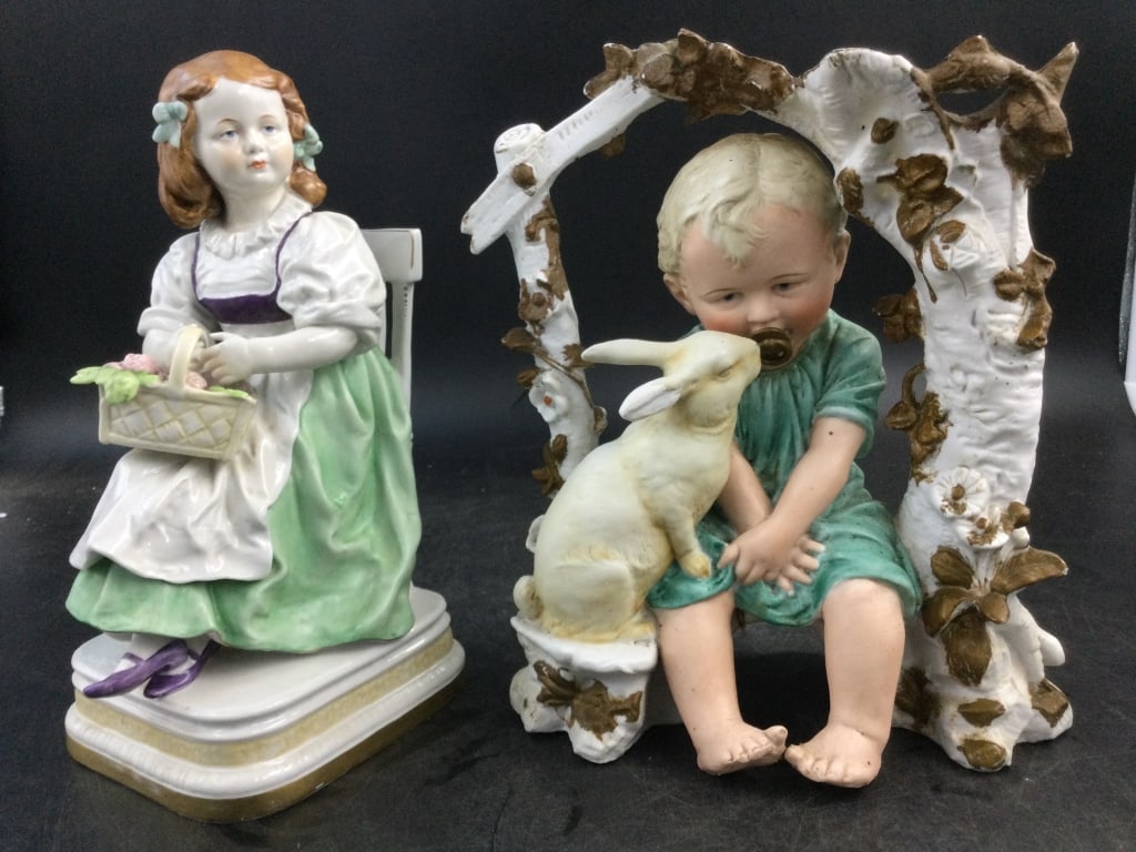 Vintage German Porcelain Figures: One is a German Bisque Porcelain Boy with bunny. Measures 9" x 7". The other piece is a porcelain statue of girl seating with flowers. Measures 9.5" x 4.5". Marked Germany on bottom. Condition is cons
