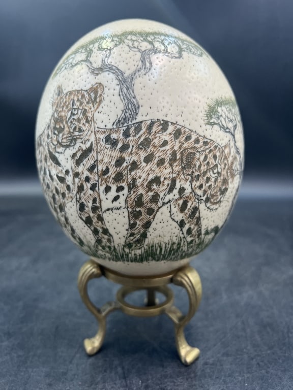 Scrimshaw Ostrich Egg: Hand scrimshawed ostrich egg on brass stand. Featuring a scene with leopard. Egg measures about 6'. Condition is good, see pictures. No refunds given.