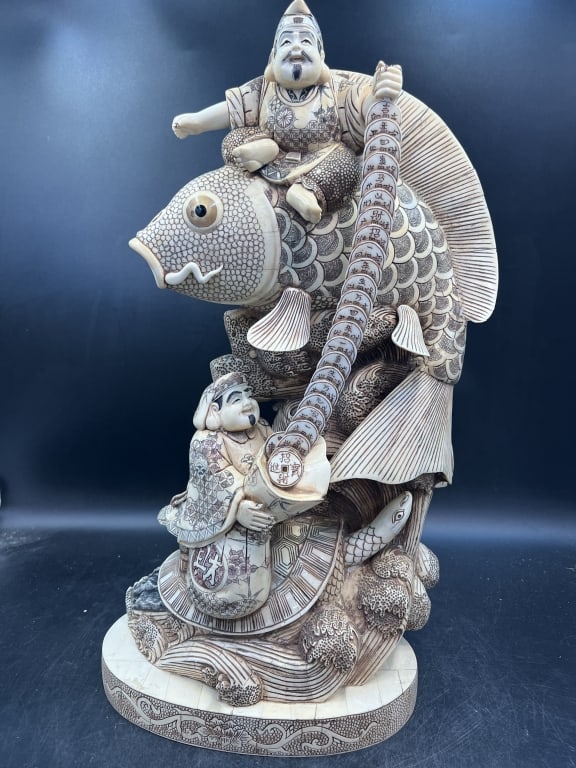 Japanese Daikokuten & Ebiisu Hippo Bone Sculpture: Neatly large statue with scrimshaw. Measures estimate 21" x 10.5" x 5.5". Made from carved hippo bone and features figures riding a large Koi fish. There is Daikokuten god of wealth and Ebisu god of f