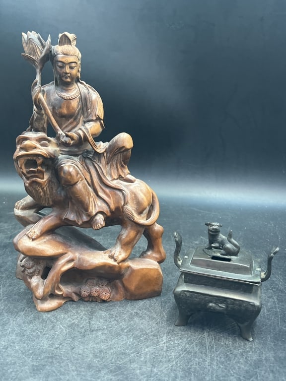 Asian Lot: There is a carved wood statue of Wenshu a Bodhisavattva. Measures 10"h x 6 1/2"l. The other piece is bronze incenses burner with foo dog. Measures 4" x 3.5'. Condition is consistent on age and use, se