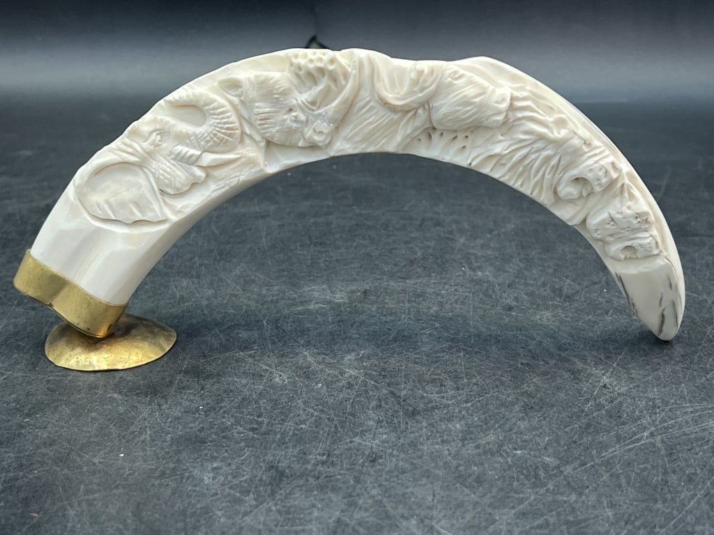 Carved War Hog Tusk on Stand: Nice intricate carving of African animals. Measures about 11" and codnition is good. See pictures. No refunds given.