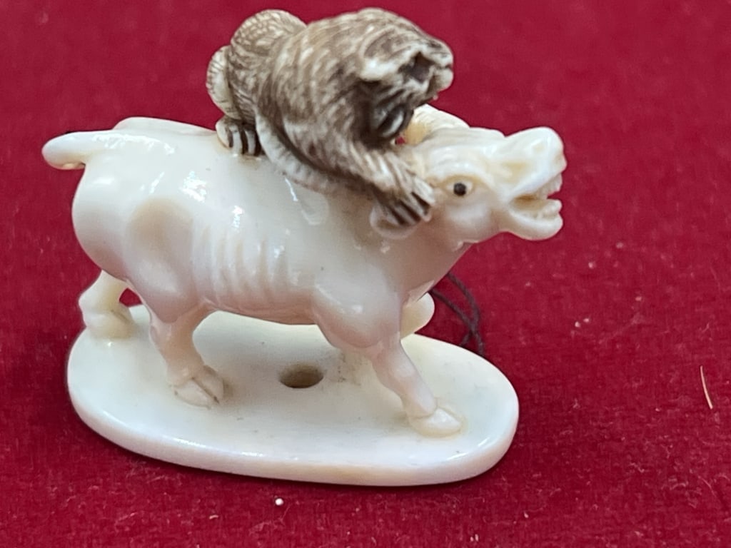 Carved Netsuke Water Buffalo and Tiger: Intricately carved piece that is signed on bottom. Tiger attempting to put down Water Buffalo. See pictures. No refunds given.