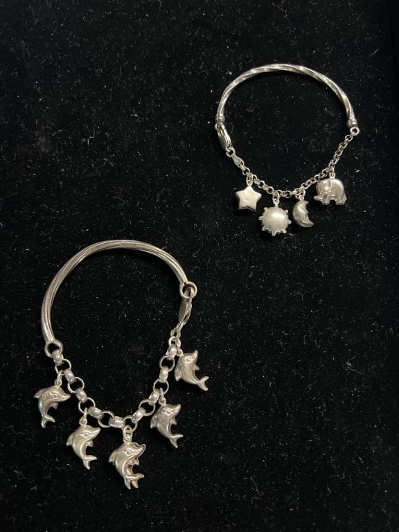 Sterling Charm Bracelets: Total of 2 in this lot. One has dolphins and the other has a variety on it. Total weight is 27 g. See pictures, condition is good. No refunds given.