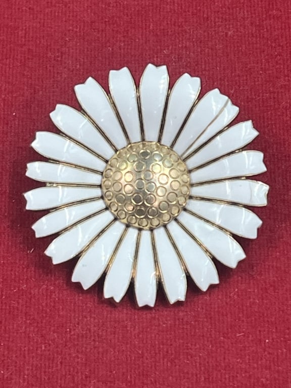 George Jensen Daisy Sterling Silver Brooch: Piece crafted from gilded sterling silver and hand painted white enamel. Design created in 1940. Versatile piece that can be worn as a brooch or pendant. White enamel petals. Marked on the back. Condi