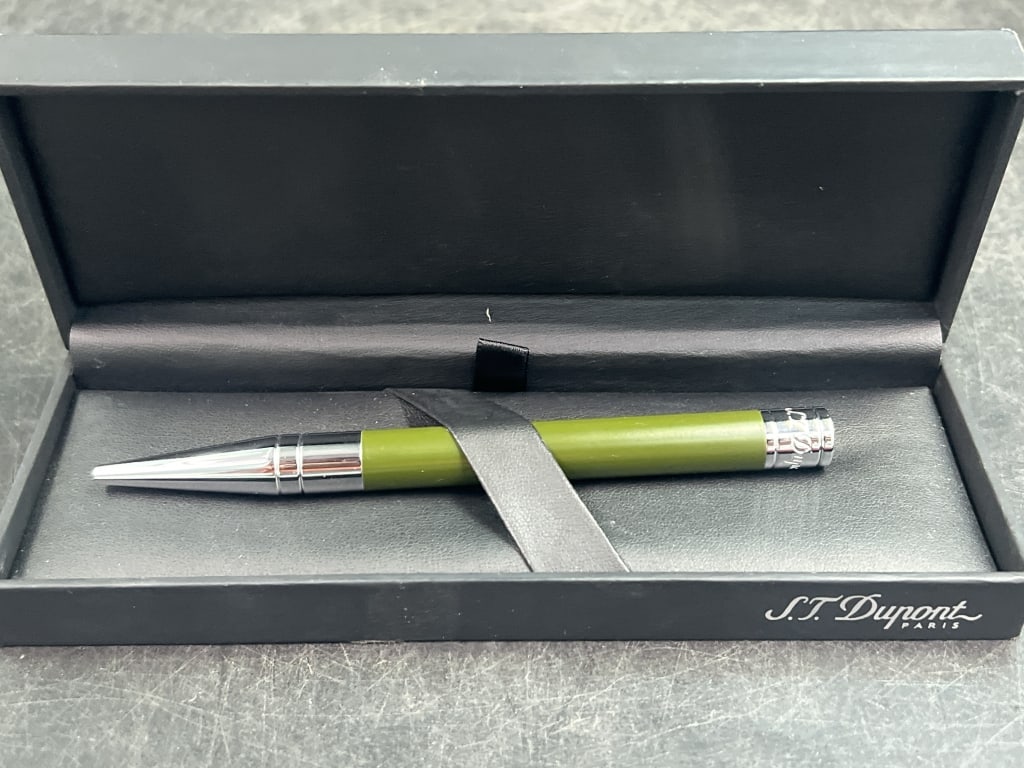 S.T. Dupont Pen: Rollerball or fountain pen model, presented in its original display box. Features a distinctive lime green lacquer body. Accented with palladium or chrome plated trim on cap, clip and barrel end. Cond