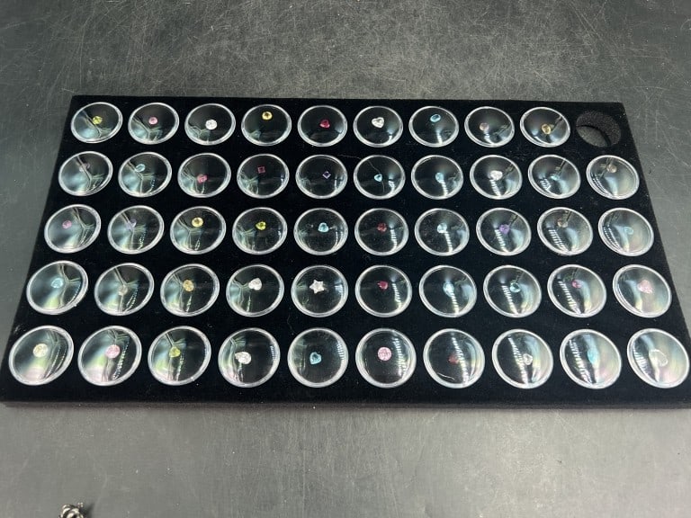 Gemstones: Total of 49 various gemstones in plastic holders. See pictures as there is a variety. Condition is good, no refunds given.