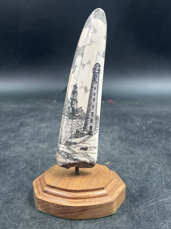 Fossilized Scrimshaw Artwork: Scene of ship and lighthouse on this fossilized walrus piece. Measures w/o base 5 1/4" and condition is good. See pictures. No refunds given.Condition Information: It is the responsibility of
