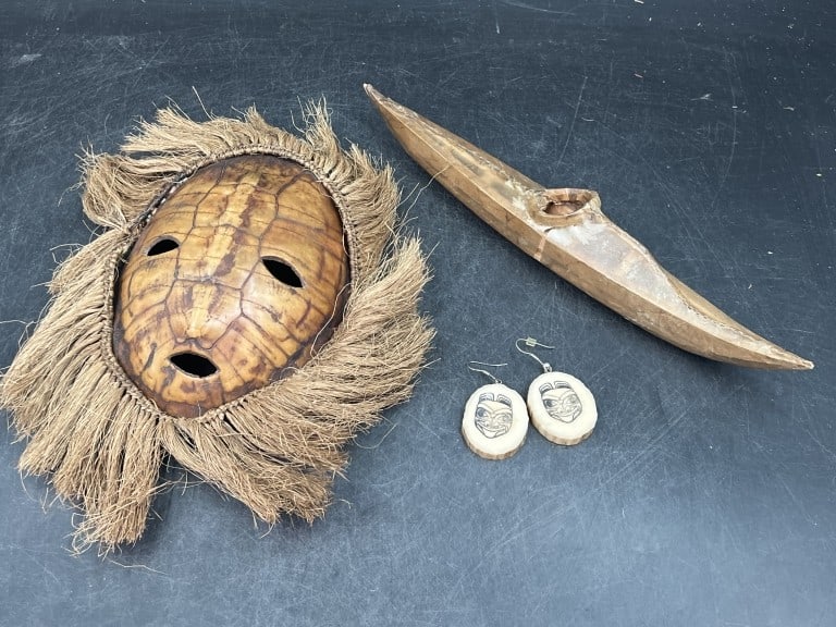 Alaskan Items: Collection of indigenous cultural items. Includes a Inuit seal skin kayak, a turtle shell marks with raffia hair and matching earrings. Condition is consistent with age and use, see pictures. No refun