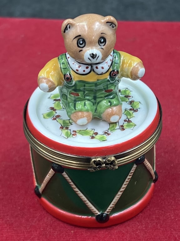 Limoge Trinket Box 'Rochard: Hinged porcelain trinket box featuring a teddy bear dressed in overalls sitting on holiday theme drum. Signed and condition is good, see pictures. No refunds given.Condition Information: It is