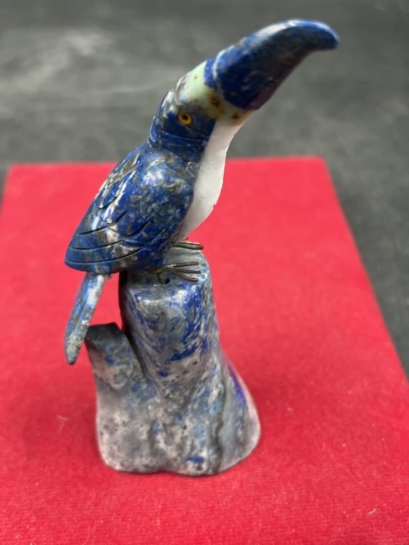 Gemstone Toucan Sculpture Lapis Lazuli: Hand crafted from lapis featuring white or calcite banding. Toucan bird perched on a matching stone tree trunk base. Measures 4 1/4"h. Condition appears good, see pictures. No refunds given.Condition