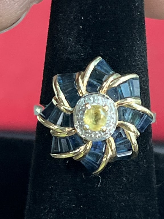 10kt Gold Foral Shaped Ring: Vintage ring with diamonds, sapphires and yellow stone in middle. Ring is in good condition, see pictures. Size 9 and weighs 4.4g. See pictures, no refunds given.Condition Information: It is