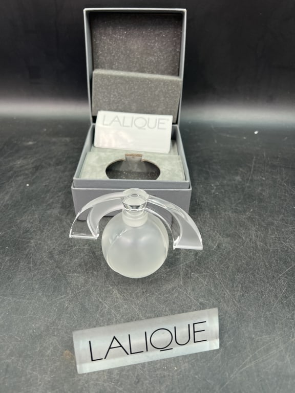 Lalique Clear Glass Perfume Bottle with Box: Features a spherical base, unique stopper design and clear, likely crystal material. There is also a Lalique display sign. Condition is good on both, see pictures. No refunds given.Condition
