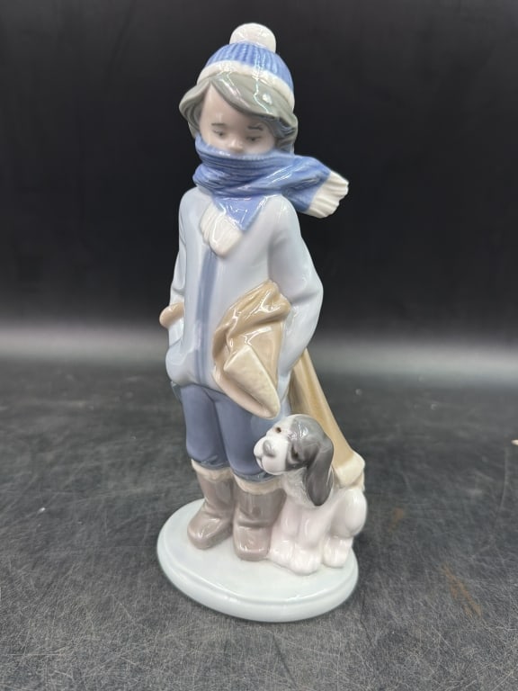 Lladro 'Winter Boy with Dog': Figure depicts a child bundled in a blue knit cap, scarf and boots accompanied by a small puppy. It measures about 8.25" and condition is good, see pictures. No refunds given.