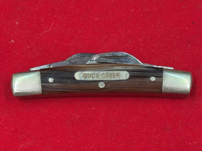 Vintage 'Bob Cat' Pocketknife: Hand made knife Solingen Germany. Features a brown wood grain handle and nickel silver bolsters. This multi blade traditional pock knife, featuring a clip, spey and sheepfoot blade configuration. .