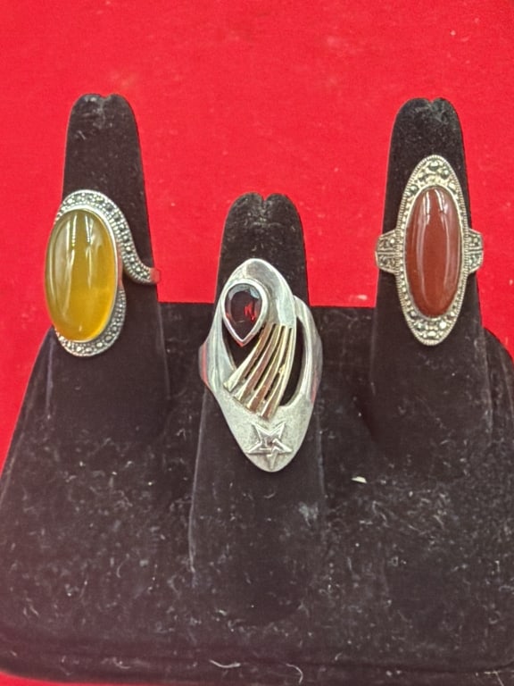 Sterling Rings: Total of 3 rings in this lot. One featuring a pear shaped red garnet stone and stylized star. The other two have large oval gemstones. Rings are size 7.5 to 9. The total weight is 23.6g. Condition is 
