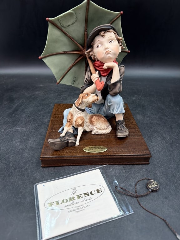 Florence Giuseppe Armani Figurine: Comes in original box and has all paperwork. "Awaiting the Rainbow". Features a young boy in a cap holding an umbrella, seated next to a dog. Handmade from porcelain and wood. Measures about 10" and