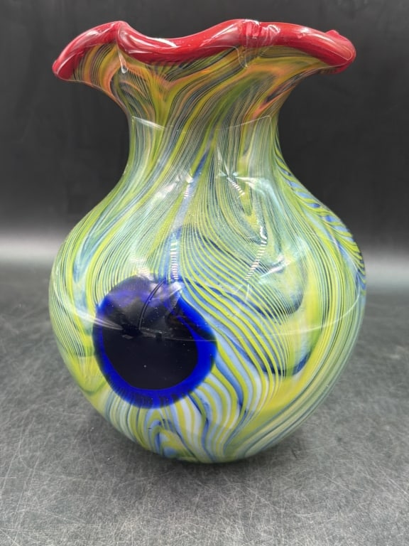 Murano Multi Colored Speckled Pattern w/Blue Eye: Hand blown Murano style art glass peacock feather vase. Features a bulbous body, vibrant ruffled red rim and distinct blue and yellow combed pattern designed to mimic the "eye" of peacock. Measures